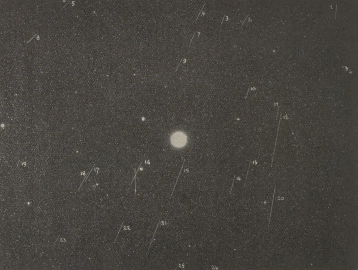 An old black and white photographic plate crossed by many faint meteor trails