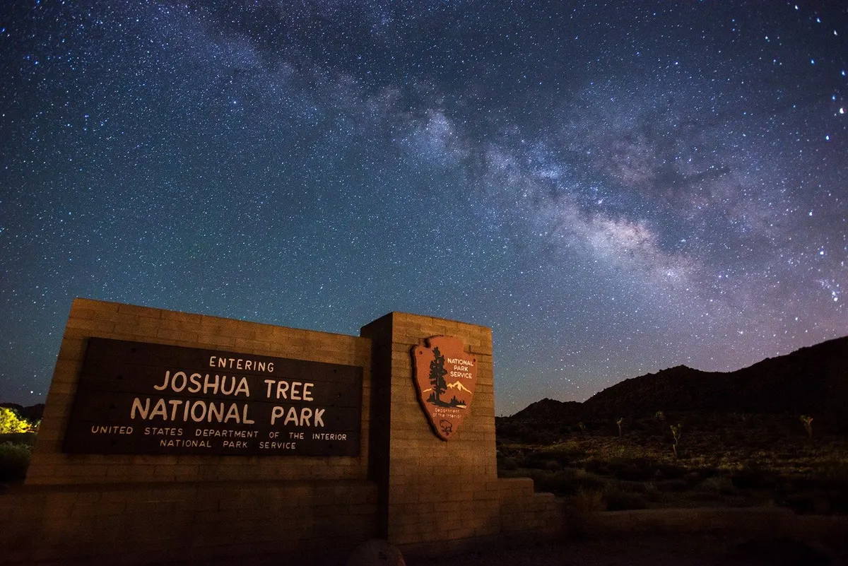 The Milky Way above the entrance sign of Joshua Tree National Park