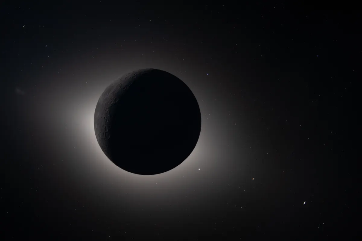The Sun hidden behind the Moon, with the glowing corona around the black disc and stars in the dark sky