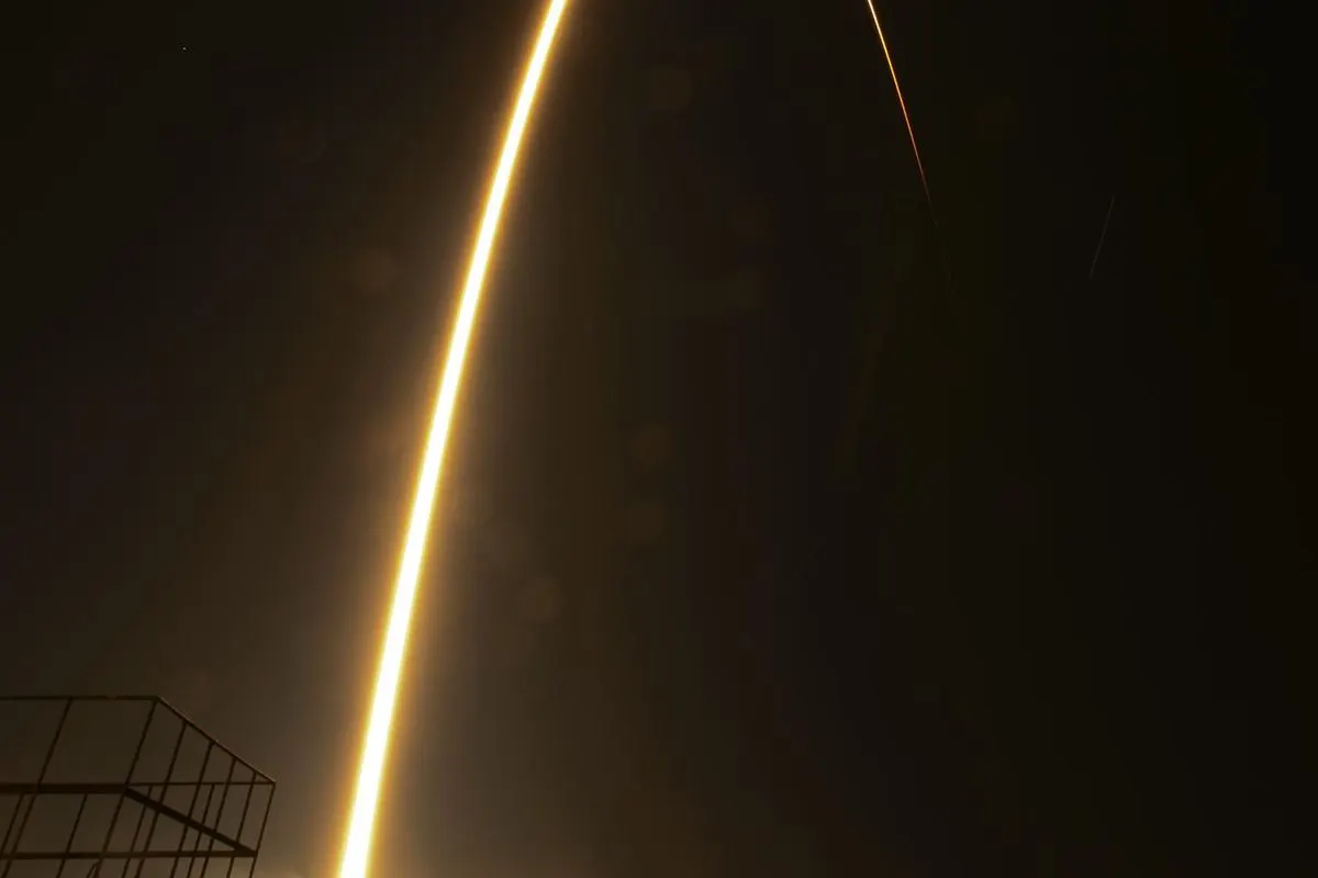 A long-exposure photo of the flight path of a Soyuz rocket against a night sky